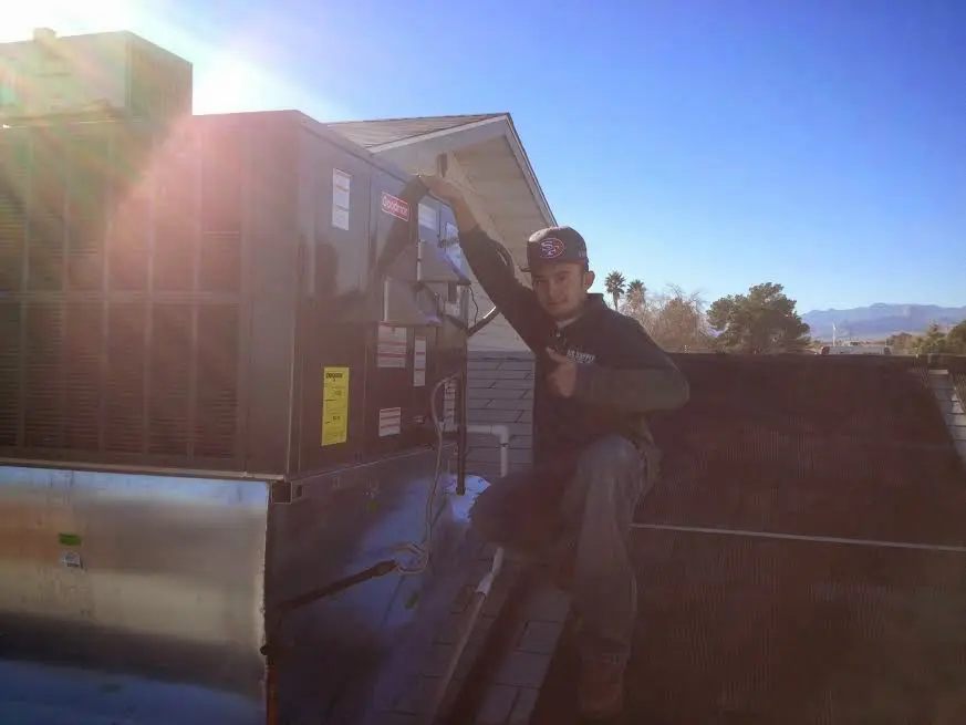HVAC technician performing Air Duct Repair on a rooftop unit in Douglas